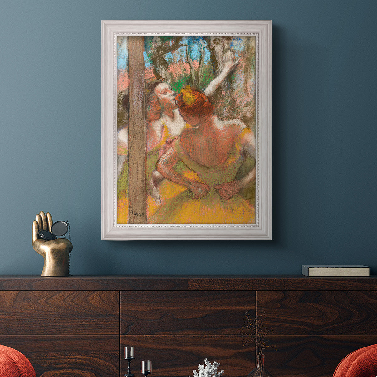 Impressionist ballet dancer composition by Edgar Degas in an ornate weathered white frame displayed in a dark-toned interior setting.