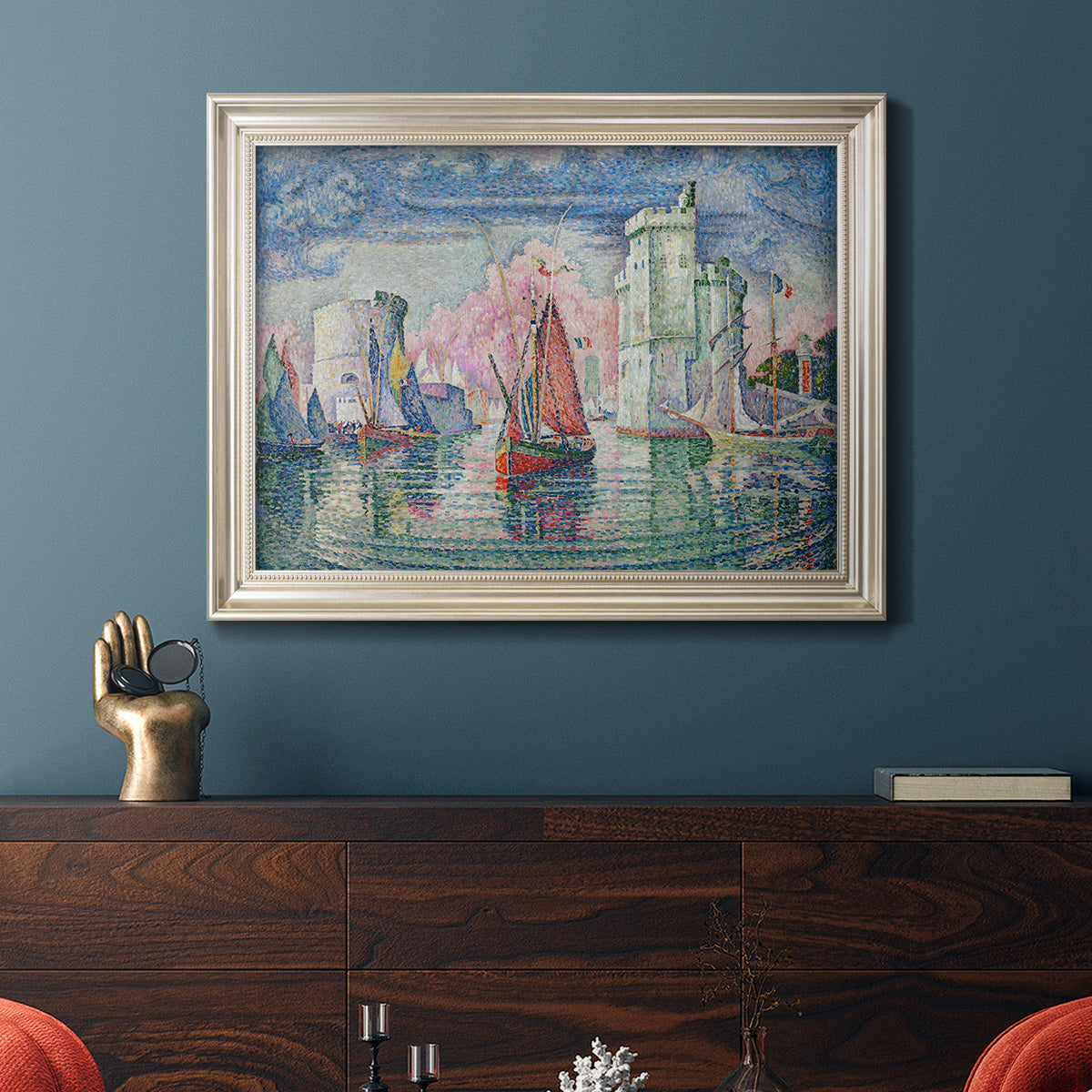 Impressionist harbor scene by Paul Signac in an ornate champagne frame displayed in a dark-toned interior setting.