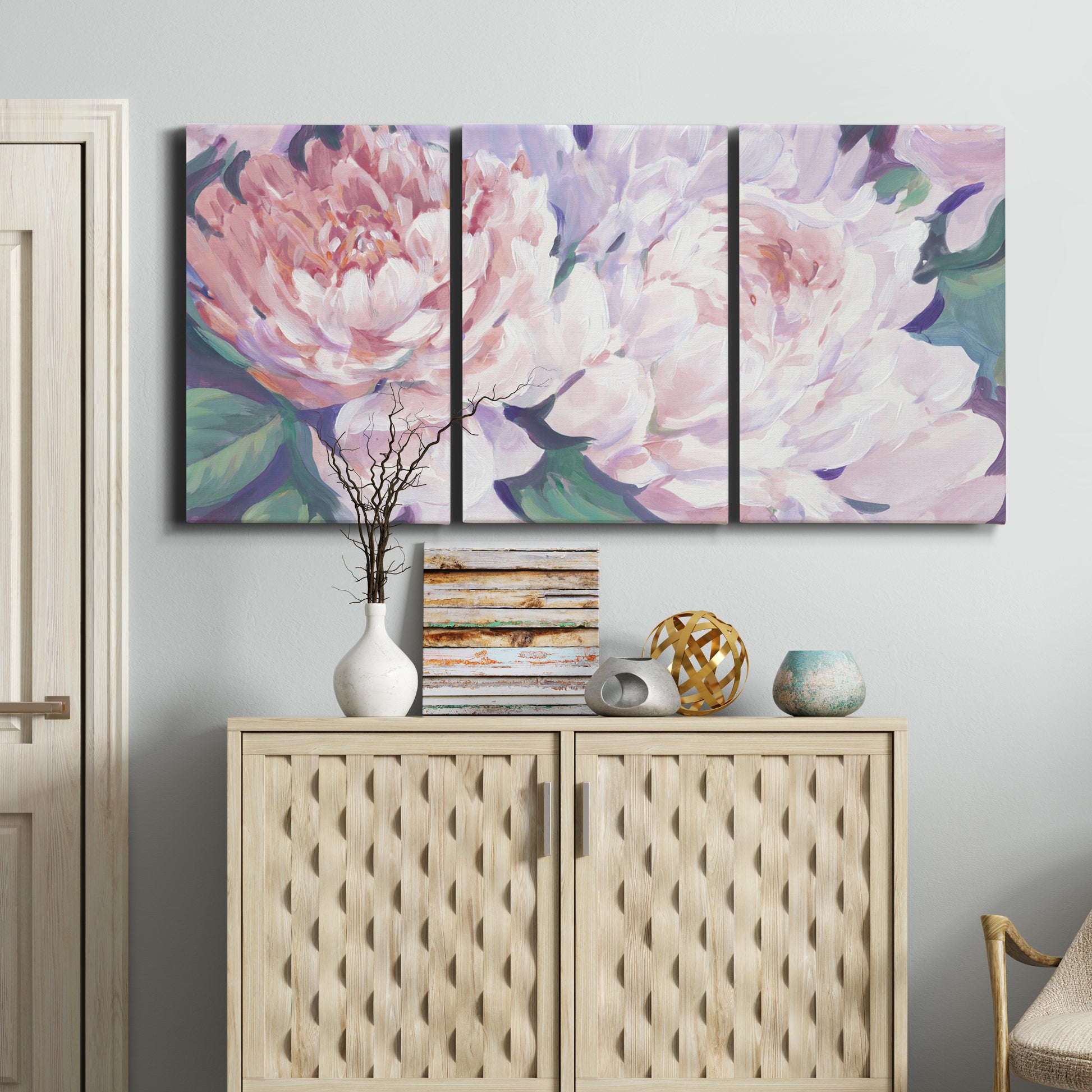 Three-panel canvas wall art featuring soft pink peonies in bloom, displayed above a cabinet in an entryway.