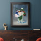 Impressionist floral still life painting by Claude Monet in an ornate black frame with gilded inner detail displayed in a dark-toned interior setting.