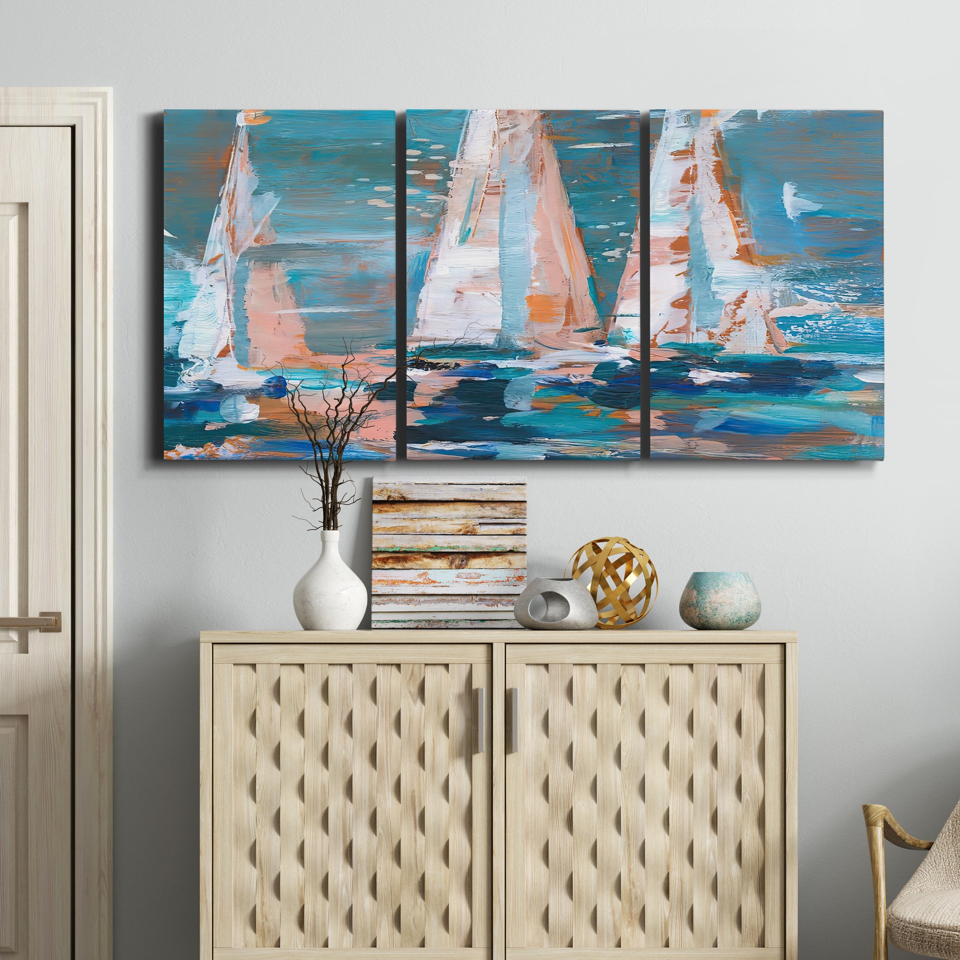 Three-panel canvas wall art featuring graphic pop style sailboats, displayed above a cabinet in an entryway.