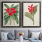 Set of two black barnwood framed canvas prints depicting paired antique botanical plate illustrations with large green leaves, red blossoms, and archival cream paper above a sofa in a contemporary living room.