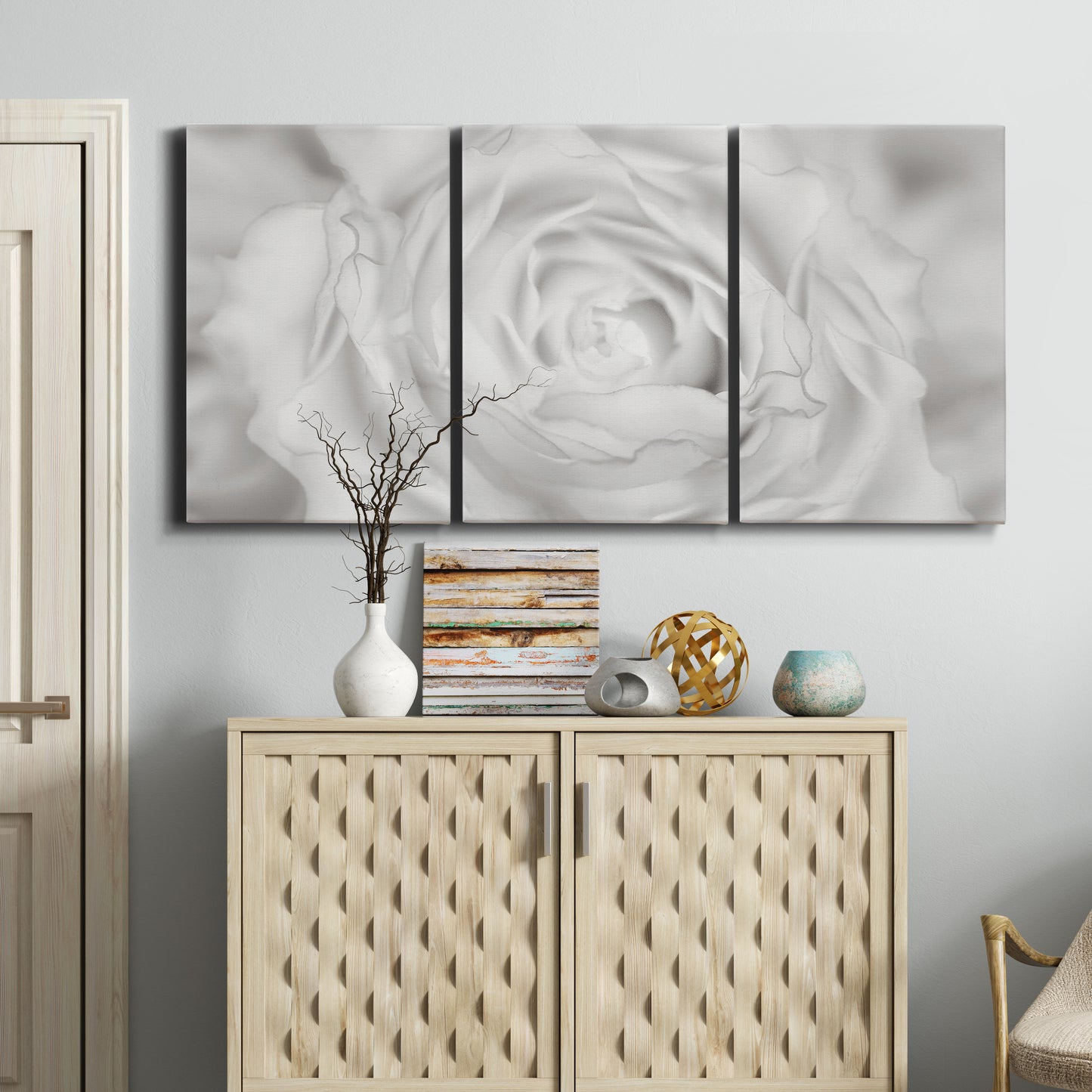 Three-panel canvas wall art featuring monochrome rose study photograph, displayed above a cabinet in an entryway.