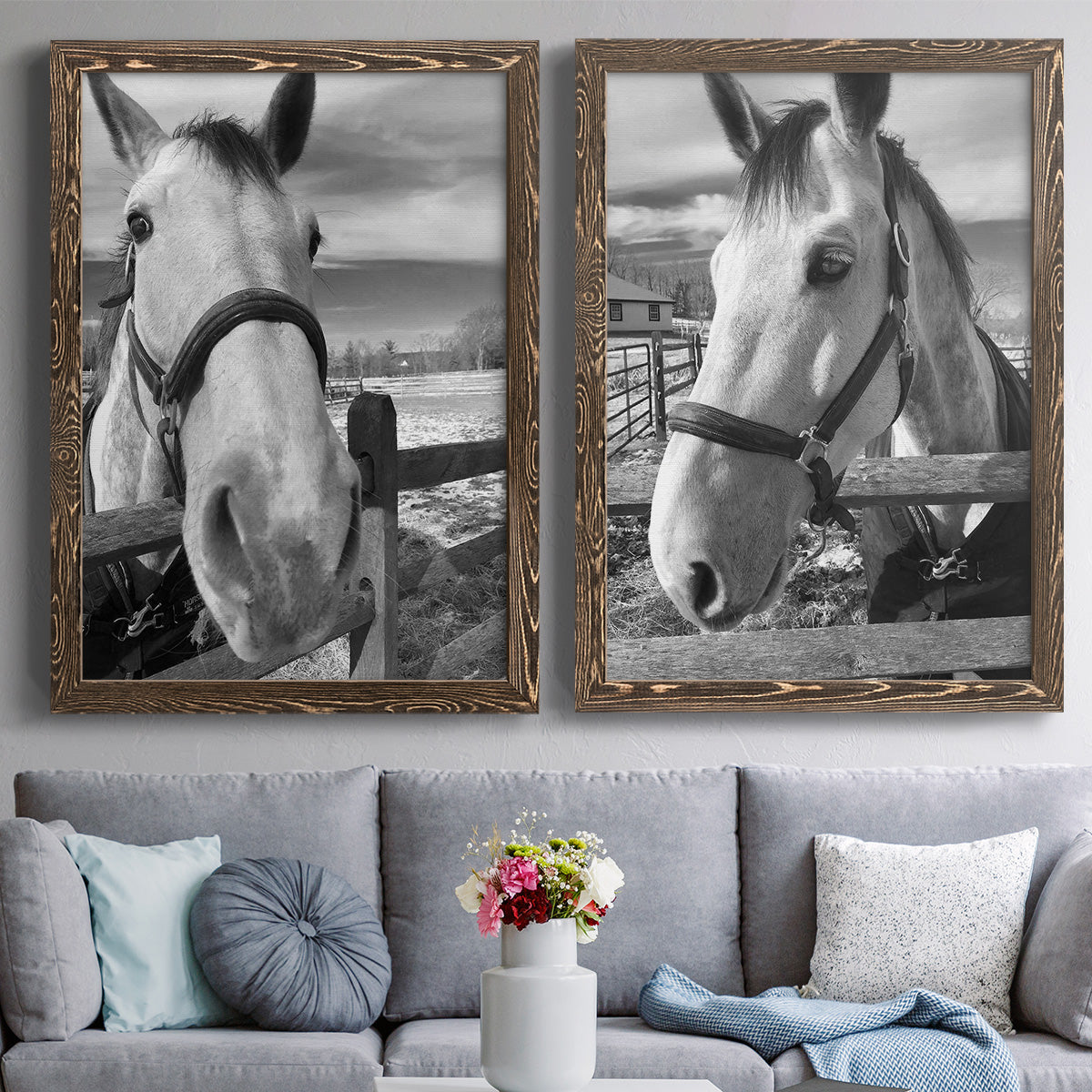 Set of two walnut barnwood framed canvas prints depicting paired modern equestrian photography with bridled faces, wooden rails, and softly blurred farm backgrounds above a sofa in a contemporary living room.