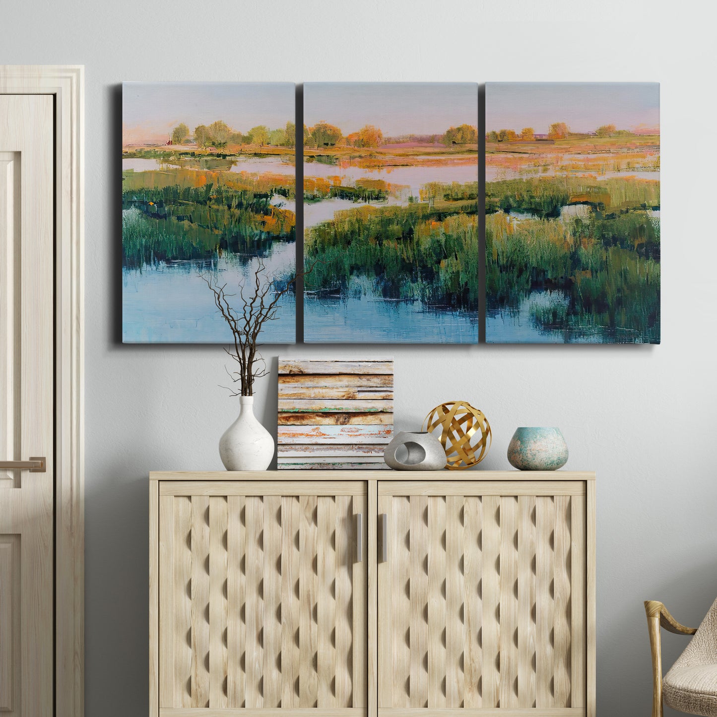 Three-panel canvas wall art featuring pastoral marshland landscape, displayed above a cabinet in an entryway.