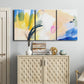 Three-panel canvas wall art featuring bright abstract candy colored strokes, displayed above a cabinet in an entryway.