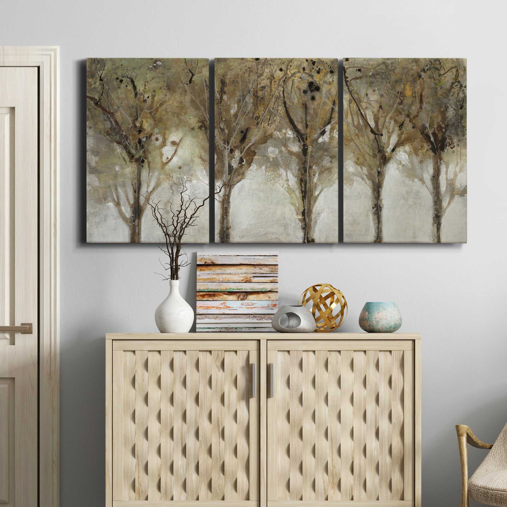 Three-panel canvas wall art featuring sunlight filtering through trees, displayed above a cabinet in an entryway.