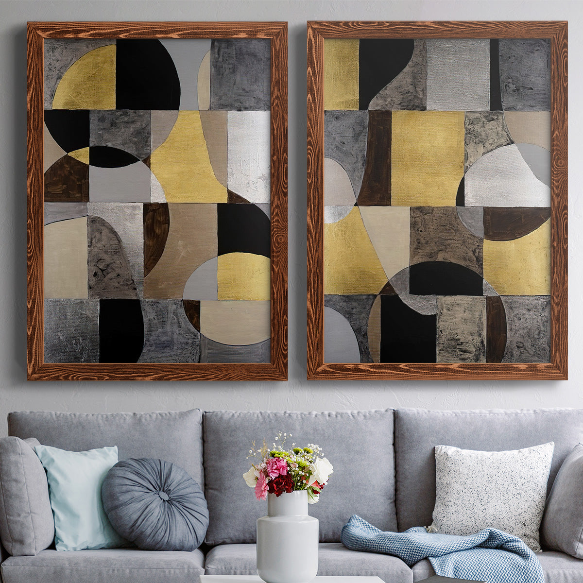 Set of two maple barnwood framed canvas prints depicting paired structured modern abstracts with semicircles, rectangles, textured panels, and metallic-looking accents above a sofa in a contemporary living room.