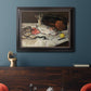 Impressionist still life painting of fish by Édouard Manet in an ornate black frame with gilded inner detail displayed in a dark-toned interior setting.
