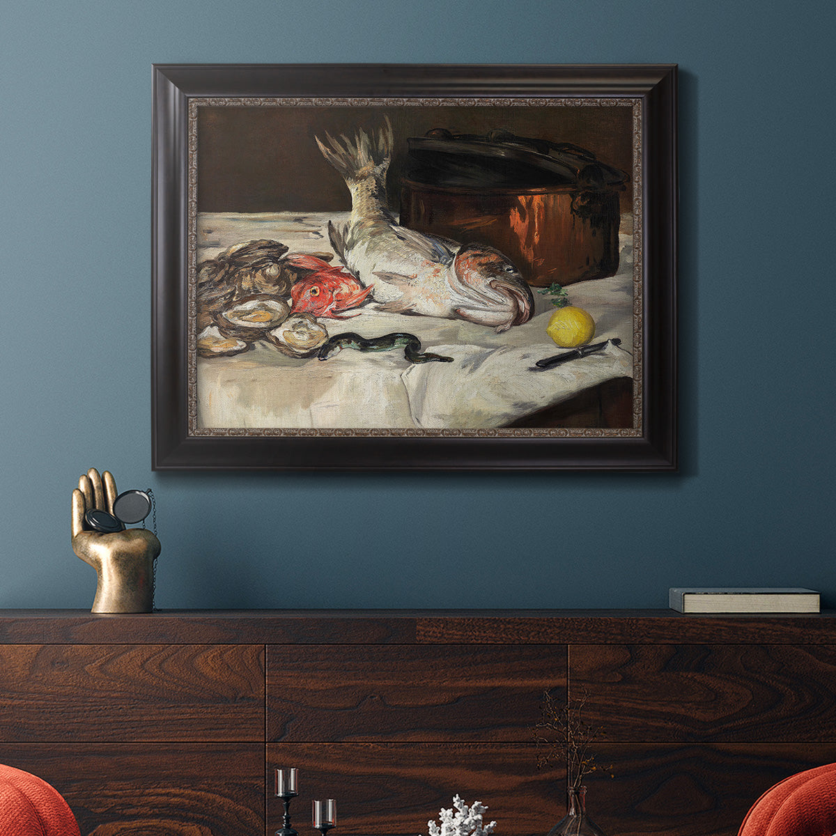 Impressionist still life painting of fish by Édouard Manet in an ornate black frame with gilded inner detail displayed in a dark-toned interior setting.