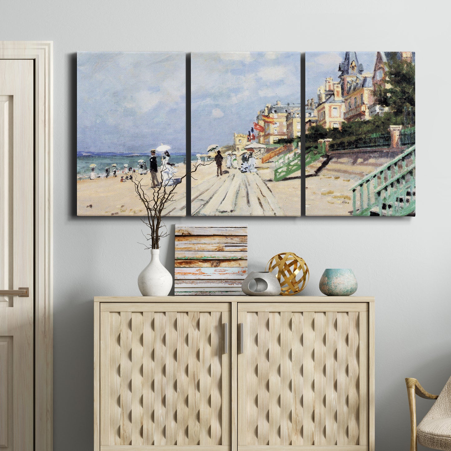 Three-panel canvas wall art featuring figures strolling along beach, displayed above a cabinet in an entryway.