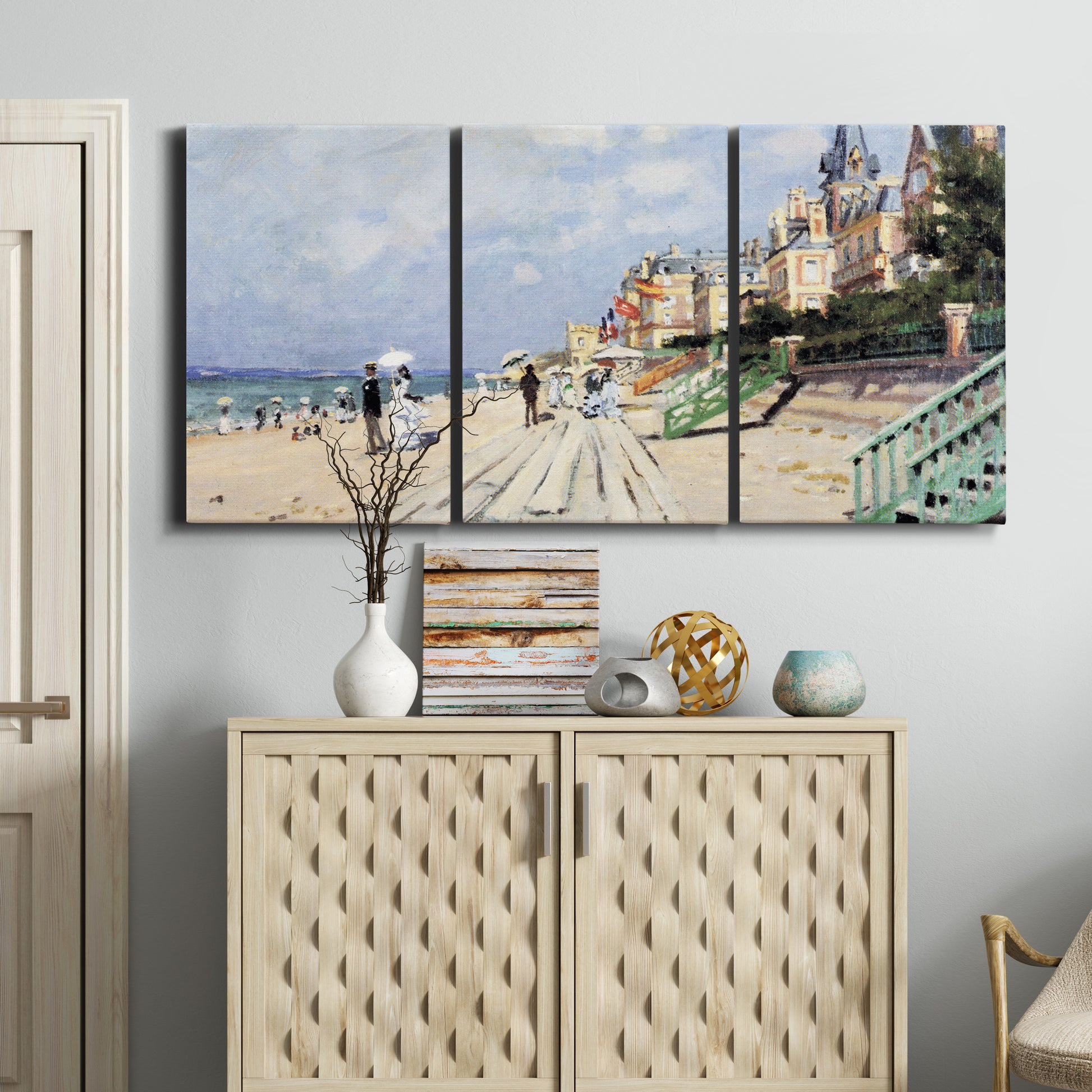 Three-panel canvas wall art featuring figures strolling along beach, displayed above a cabinet in an entryway.
