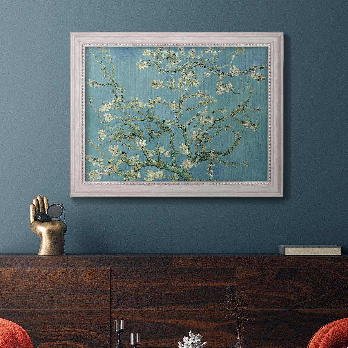 Impressionist flowering almond branch painting by Vincent van Gogh in an ornate weathered white frame displayed in a dark-toned interior setting.