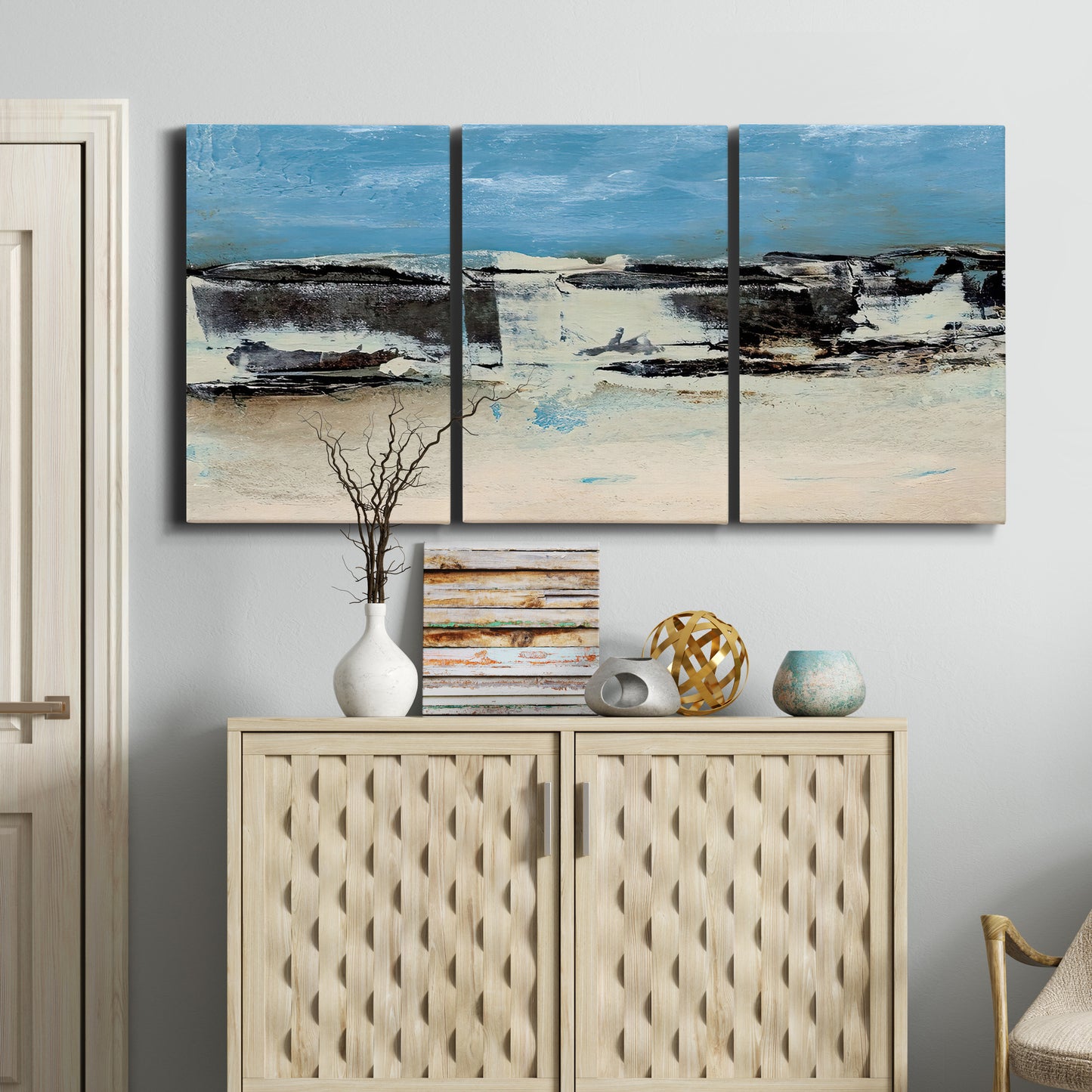 Three-panel canvas wall art featuring abstract bridge landscape in cyan, displayed above a cabinet in an entryway.