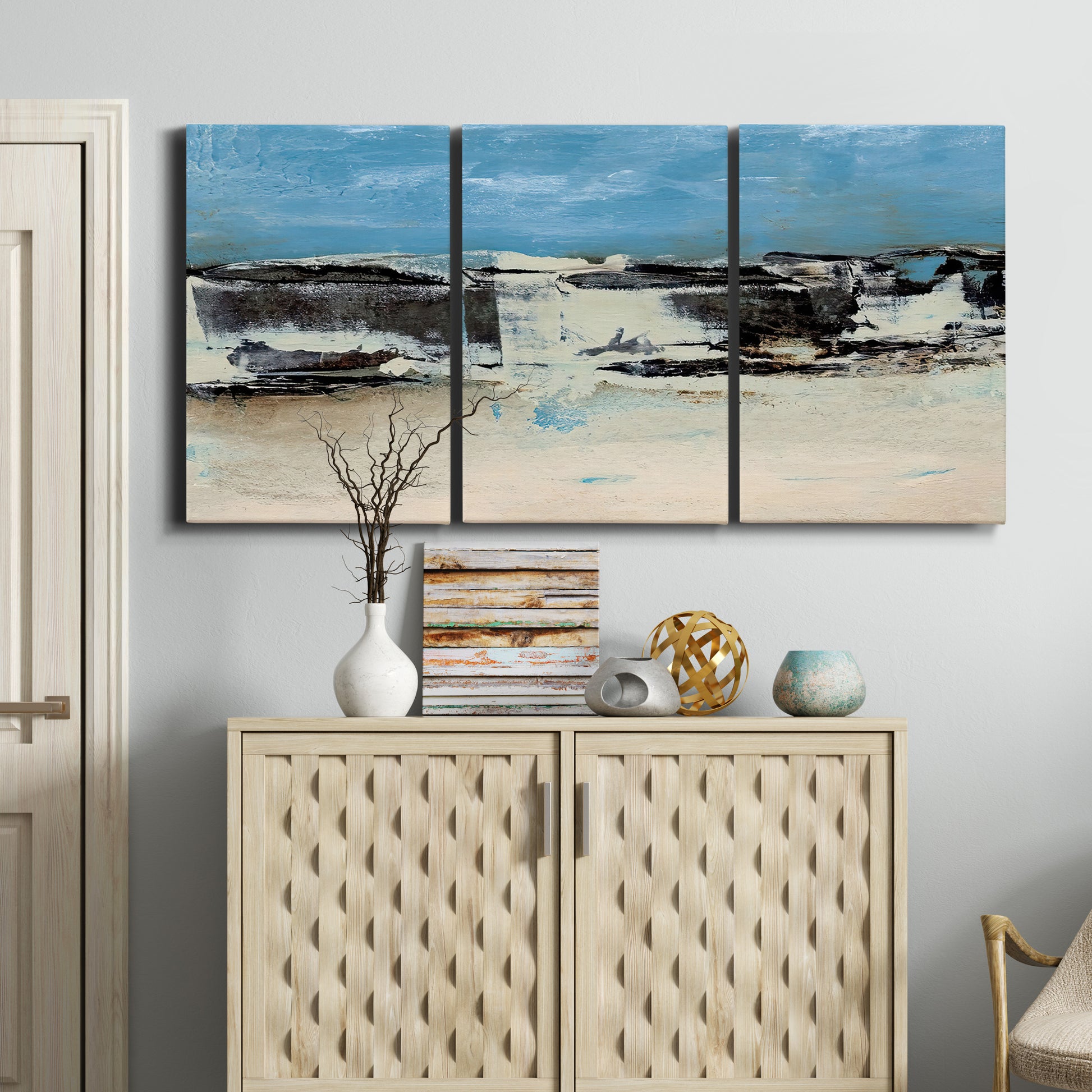 Three-panel canvas wall art featuring abstract bridge landscape in cyan, displayed above a cabinet in an entryway.