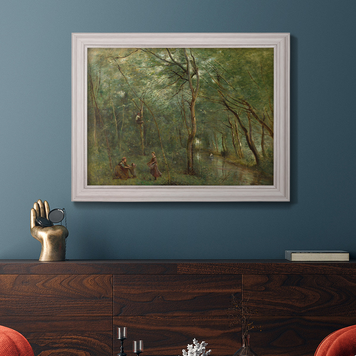 Traditional rural landscape scene with figures by Jean-Baptiste-Camille Corot in an ornate weathered white frame displayed in a dark-toned interior setting.