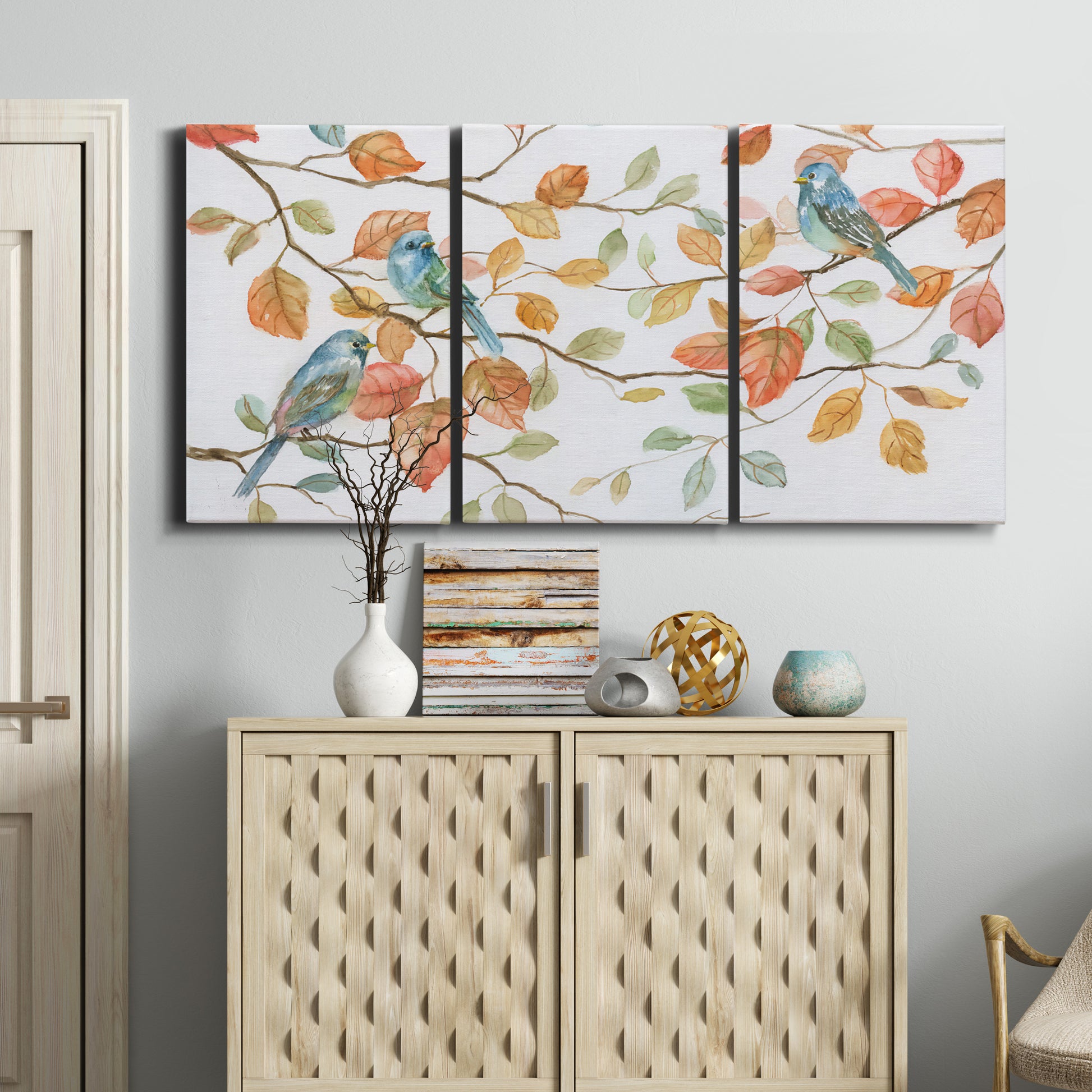Three-panel canvas wall art featuring decorative bird trio illustration, displayed above a cabinet in an entryway.