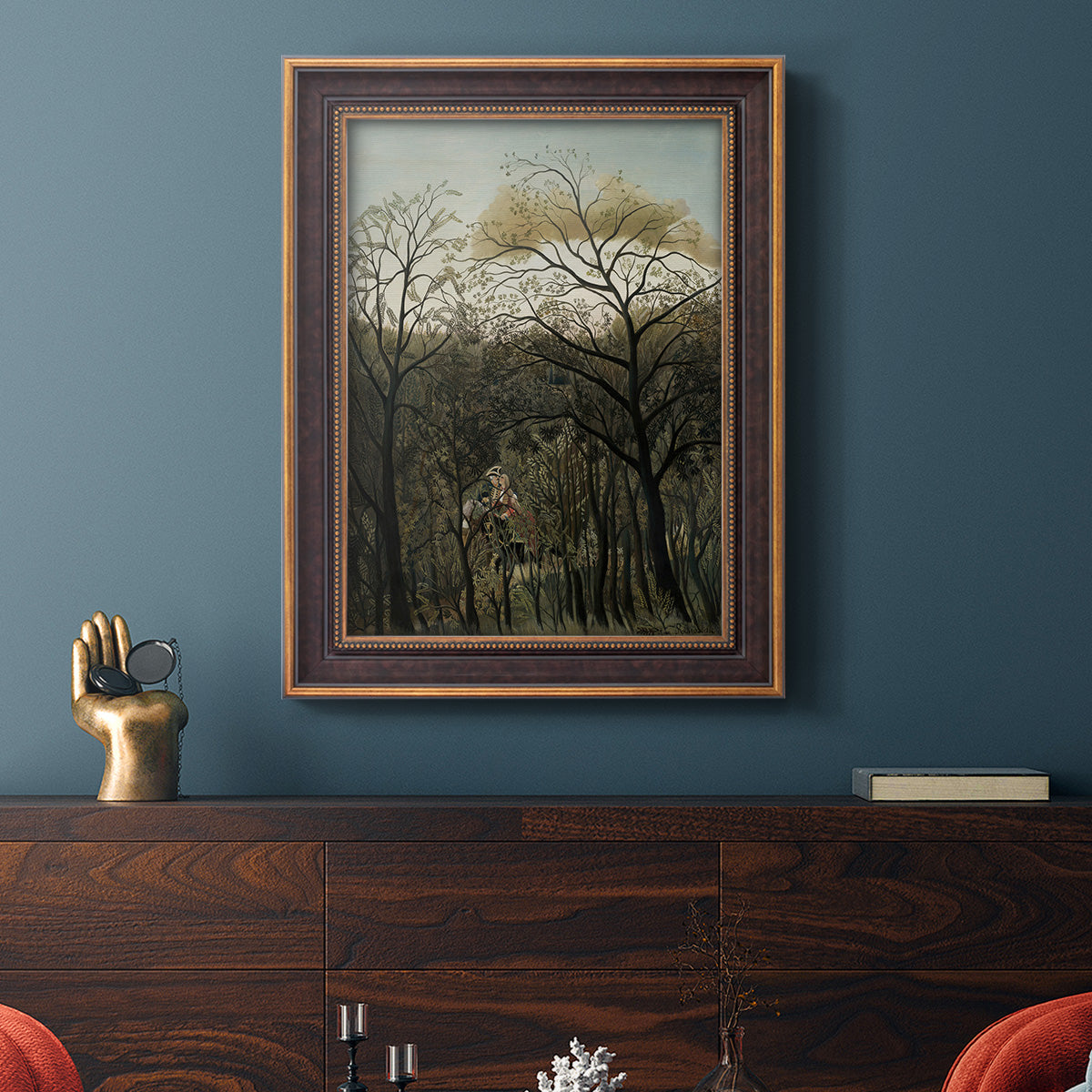 Dreamlike forest landscape scene by Henri Rousseau in an ornate bronzed mahogany wood frame displayed in a dark-toned interior setting.