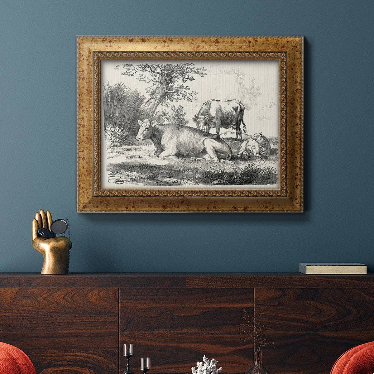 Classical pastoral landscape artwork by Nicolas Berchem in an ornate vintage gold frame displayed in a dark-toned interior setting.