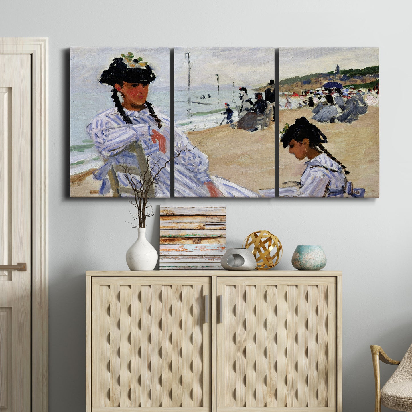 Three-panel canvas wall art featuring figures walking along sandy beach, displayed above a cabinet in an entryway.