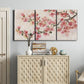 Three-panel canvas wall art featuring blooming cherry blossom branches, displayed above a cabinet in an entryway.