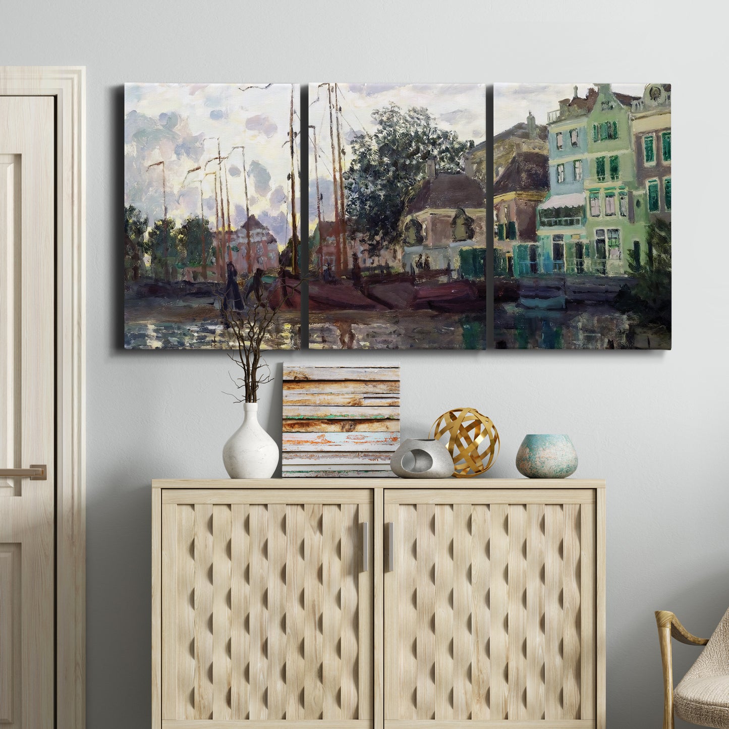Three-panel canvas wall art featuring riverside town dike at evening, displayed above a cabinet in an entryway.
