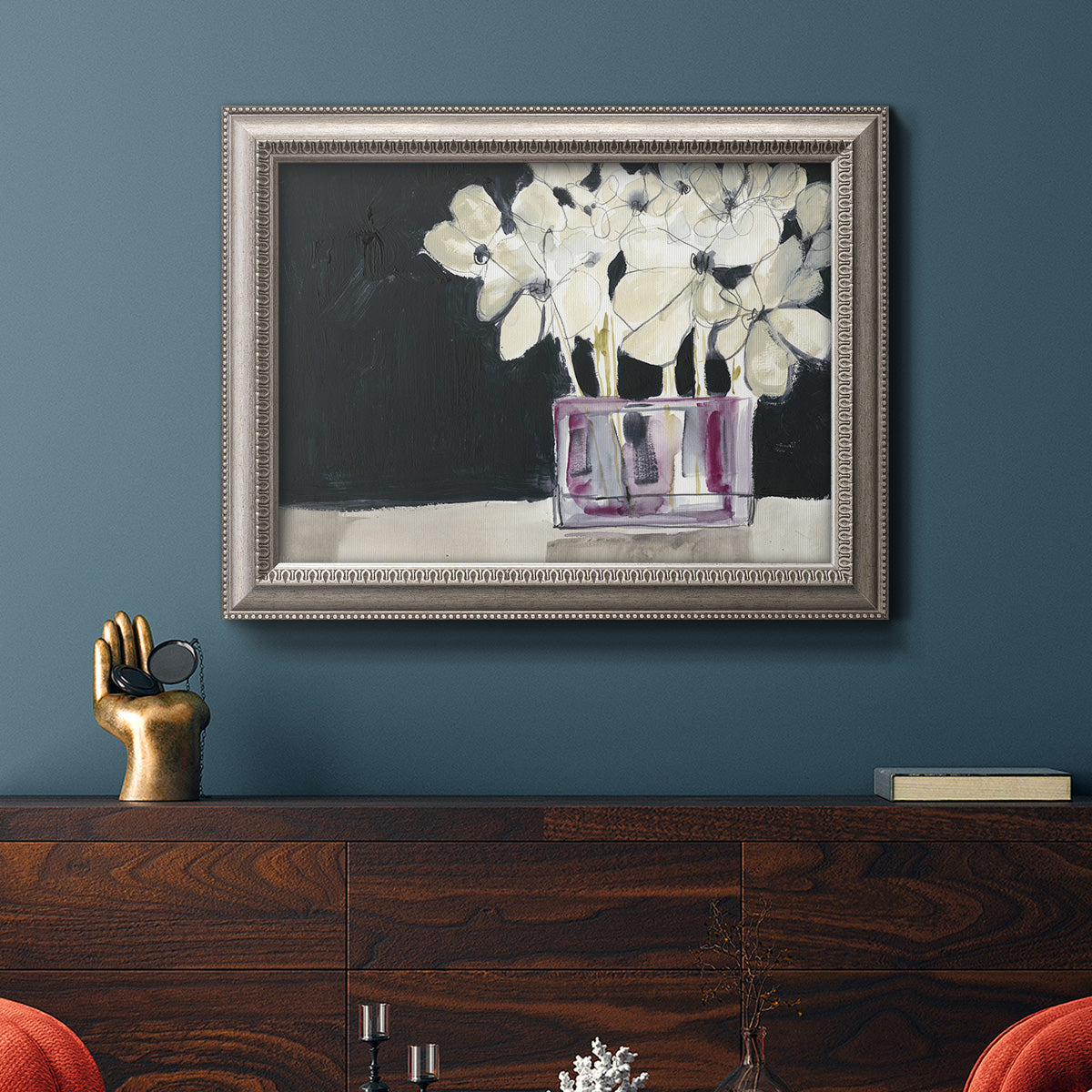 Modern abstract white floral watercolor artwork in an ornate vintage silver frame displayed in a dark-toned interior setting.