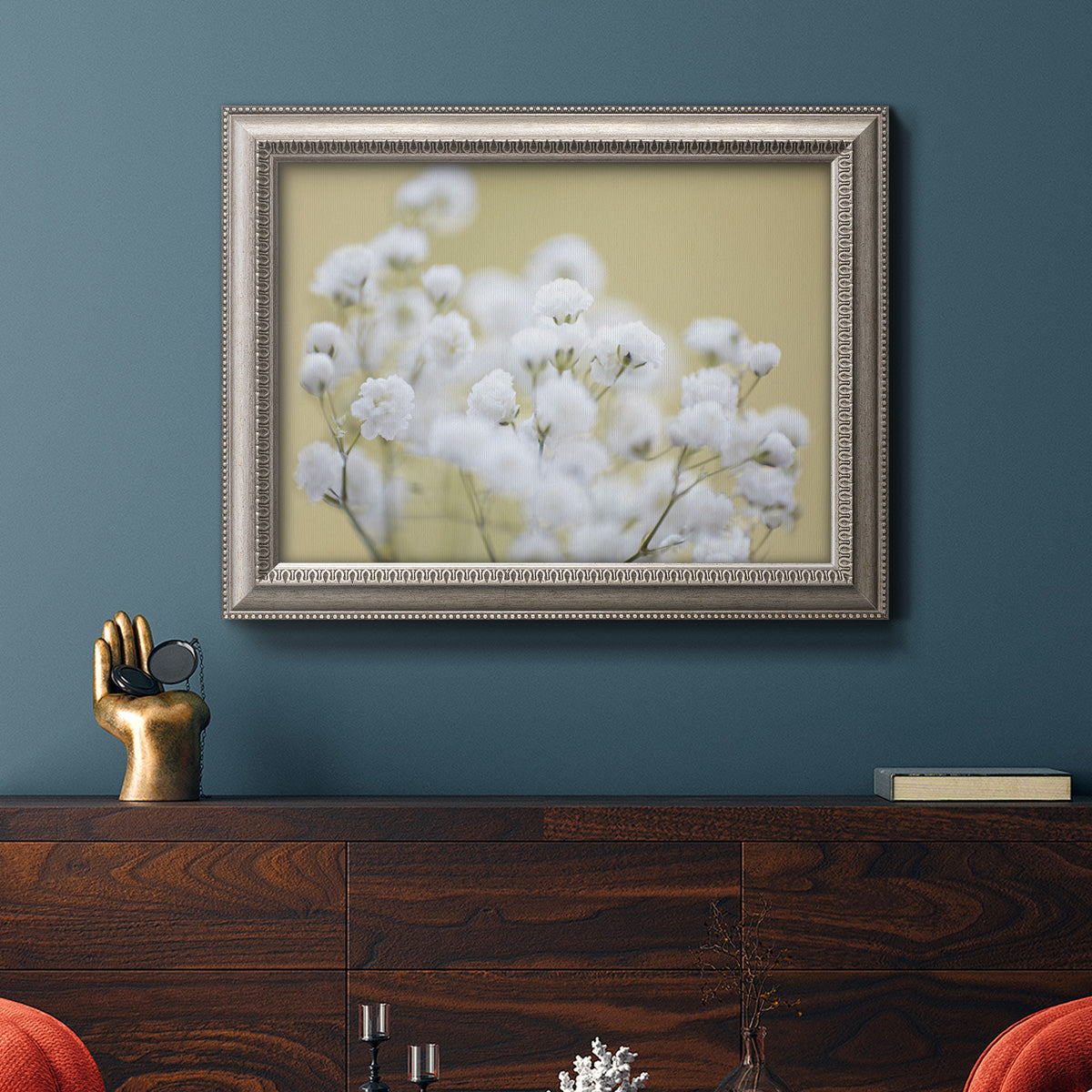 Minimal floral baby’s breath photography in an ornate vintage silver frame displayed in a dark-toned interior setting.