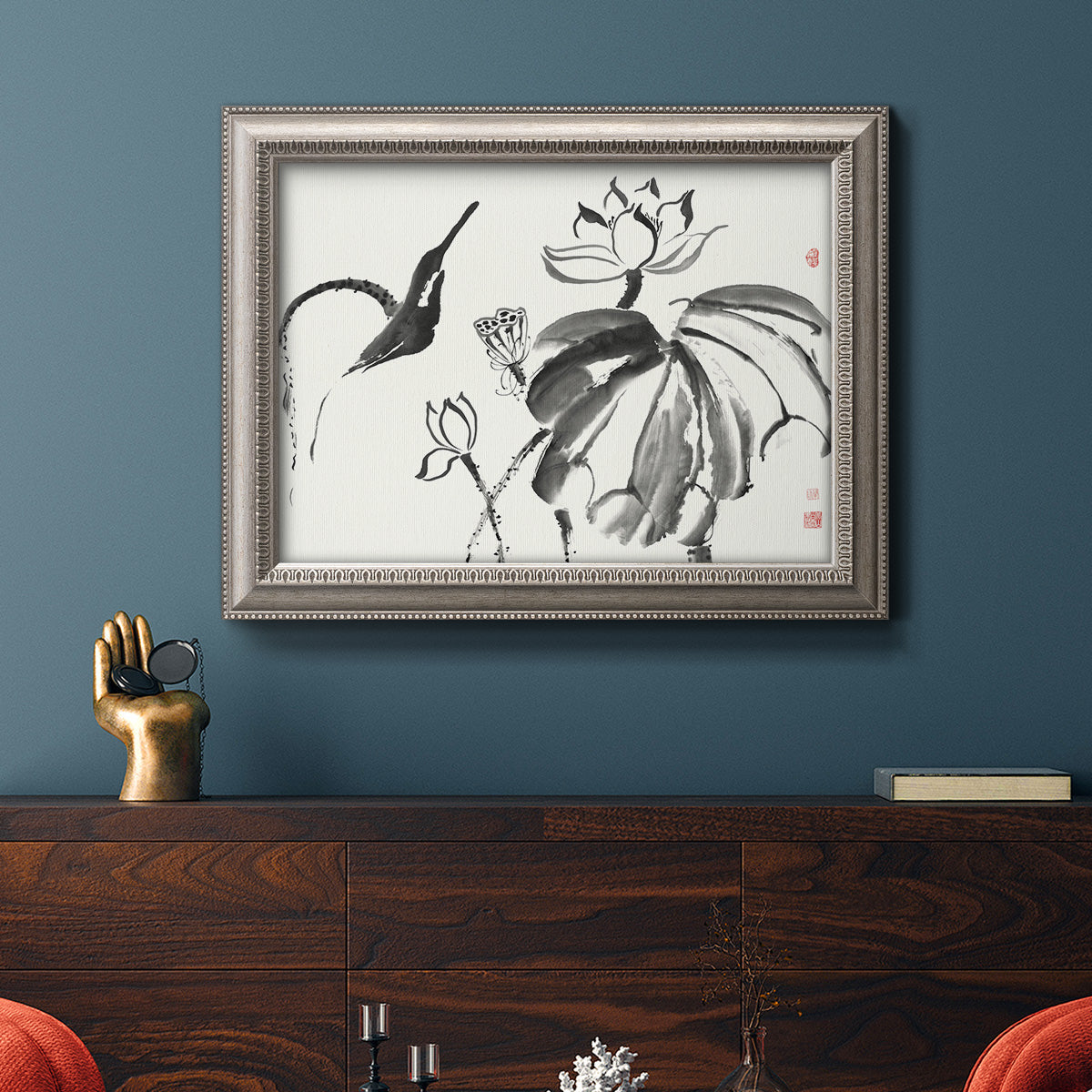 Asian-inspired lotus flower illustration in an ornate vintage silver frame displayed in a dark-toned interior setting.