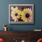 Contemporary yellow Susan floral photograph in an ornate vintage silver frame displayed in a dark-toned interior setting.