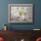 Close up view of peony petals in an ornate vintage silver frame displayed in a dark-toned interior setting.