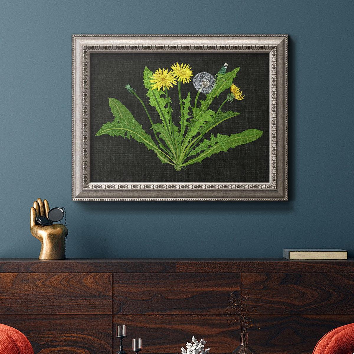 Classic botanical dandelion illustration in an ornate vintage silver frame displayed in a dark-toned interior setting.