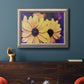 Bright black-eyed Susan flower photography in an ornate vintage silver frame displayed in a dark-toned interior setting.