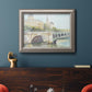 Classical watercolor painting of a French bridge in an ornate vintage silver frame displayed in a dark-toned interior setting.