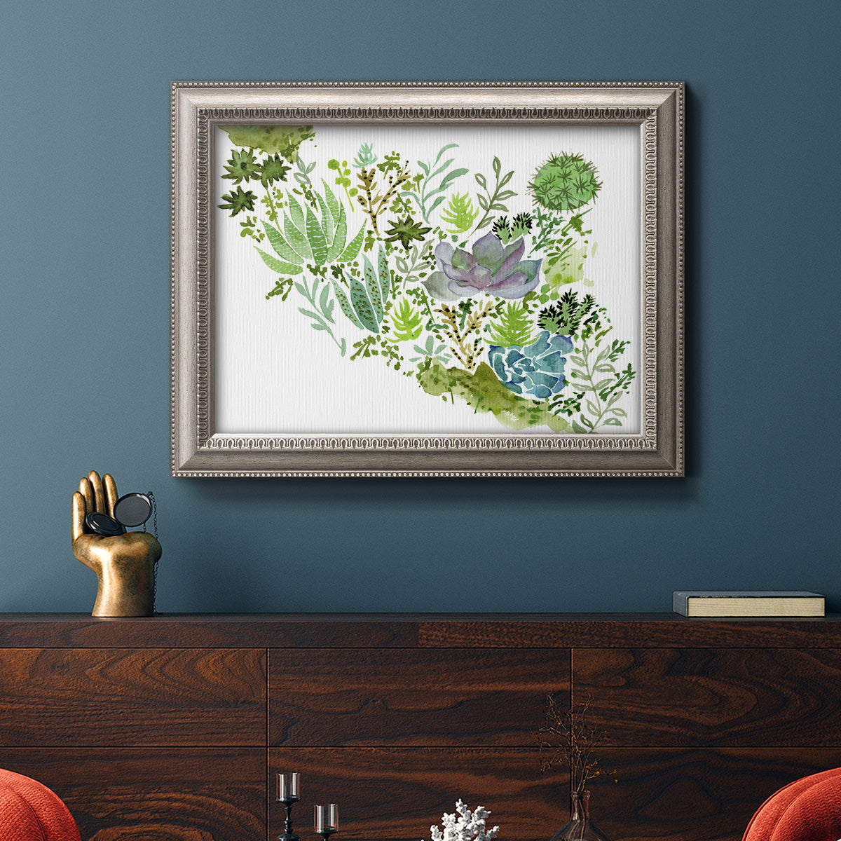 Contemporary abstract succulent botanical watercolor in an ornate vintage silver frame displayed in a dark-toned interior setting.
