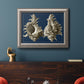 Vintage nautical conch shell artwork on navy background in an ornate vintage silver frame displayed in a dark-toned interior setting.