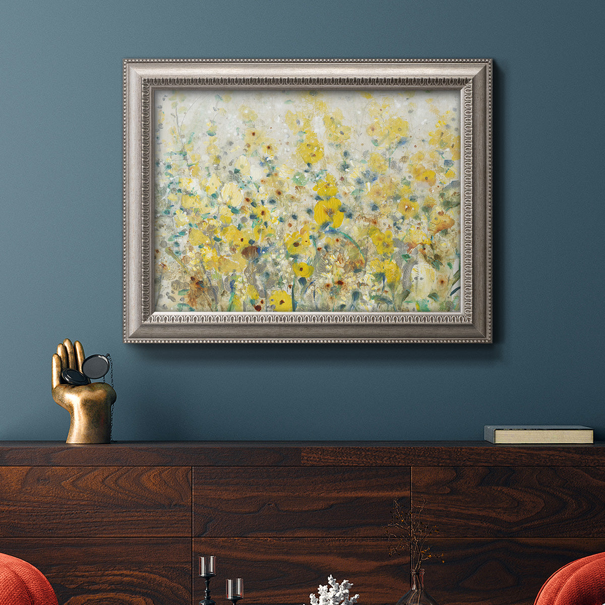 French country floral garden artwork in an ornate vintage silver frame displayed in a dark-toned interior setting.
