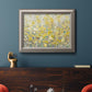 Impressionist floral garden painting in an ornate vintage silver frame displayed in a dark-toned interior setting.