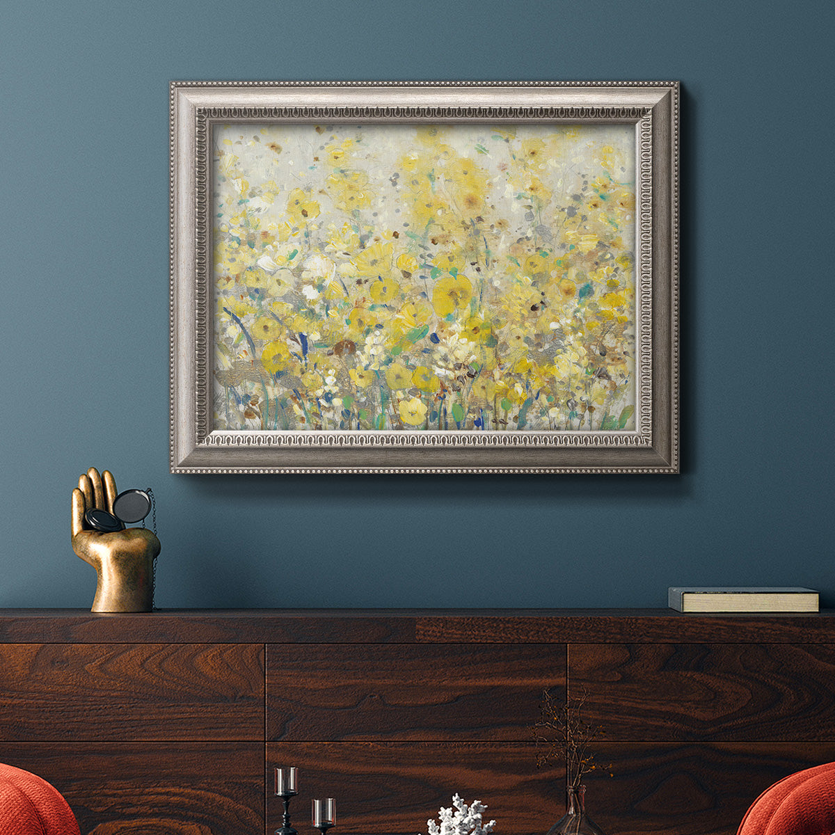 Impressionist floral garden painting in an ornate vintage silver frame displayed in a dark-toned interior setting.