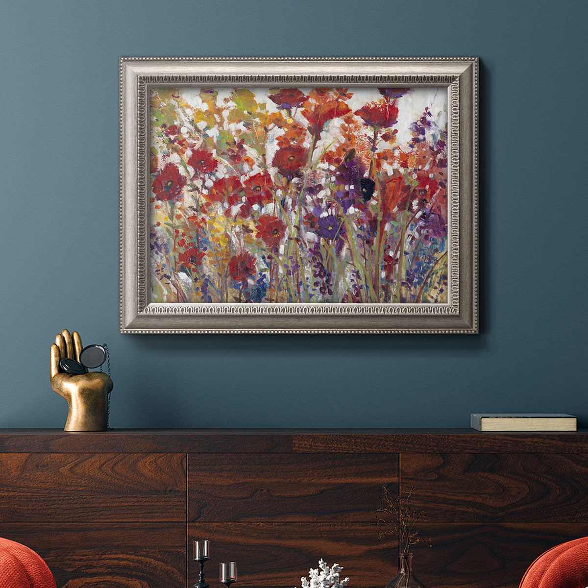 French country floral bouquet painting in an ornate vintage silver frame displayed in a dark-toned interior setting.