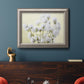 Soft-focus baby’s breath flower photograph in an ornate vintage silver frame displayed in a dark-toned interior setting.