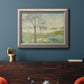 Traditional watercolor tree landscape artwork in an ornate vintage silver frame displayed in a dark-toned interior setting.