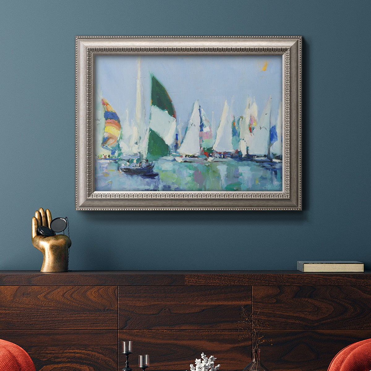 Coastal harbor watercolor painting in an ornate vintage silver frame displayed in a dark-toned interior setting.