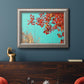 Red autumn leaves against a blue sky in an ornate vintage silver frame displayed in a dark-toned interior setting.