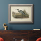 Antique blue heron bird illustration by John James Audubon in an ornate vintage silver frame displayed in a dark-toned interior setting.