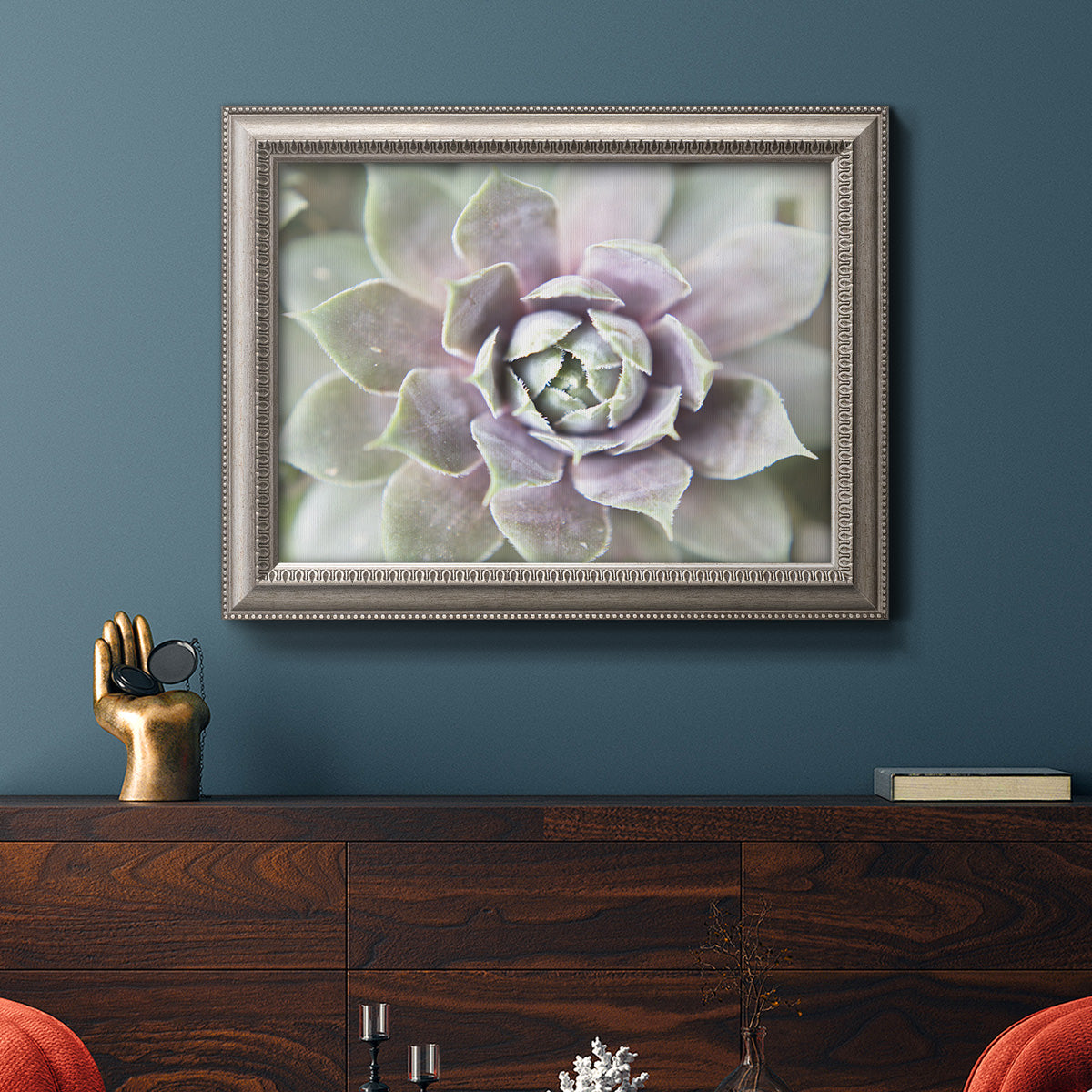 Soft abstract floral botanical photography in an ornate vintage silver frame displayed in a dark-toned interior setting.