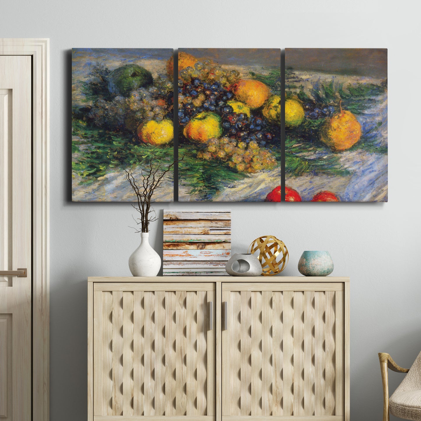 Three-panel canvas wall art featuring still life with pears and grapes, displayed above a cabinet in an entryway.