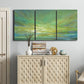 Three-panel canvas wall art featuring coastal shoreline under open sky, displayed above a cabinet in an entryway.