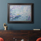 Impressionist industrial harbor scene by Paul Signac in an ornate black frame with gilded inner detail displayed in a dark-toned interior setting.