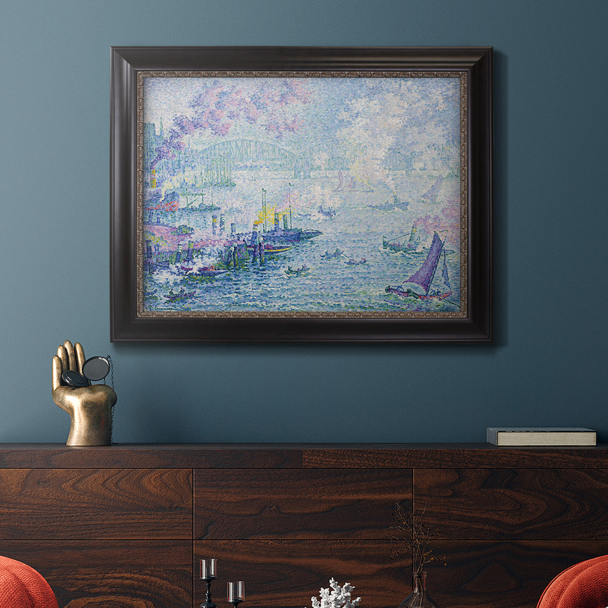 Impressionist industrial harbor scene by Paul Signac in an ornate black frame with gilded inner detail displayed in a dark-toned interior setting.
